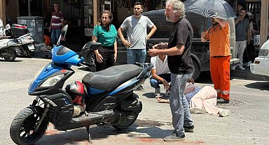 Kazada yaralanan genç kadına esnaftan şemsiyeli destek