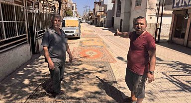 Tozdan bunalan mahalleli çareyi sokağa halı sermekte buldu