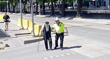 Trafik polisinin yürümekte zorlanan yaşlı adama yardımı yürekleri ısıttı