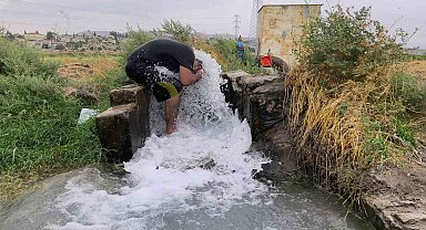 Kavurucu sıcakta elbisesini bile çıkarmadan buz gibi sondaj suyunda serinledi