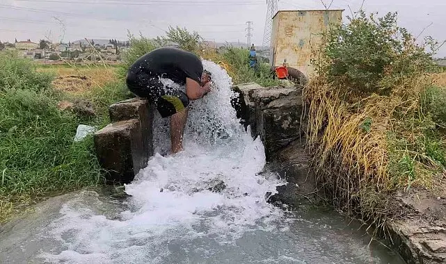 Kavurucu sıcakta elbisesini bile çıkarmadan buz gibi sondaj suyunda serinledi