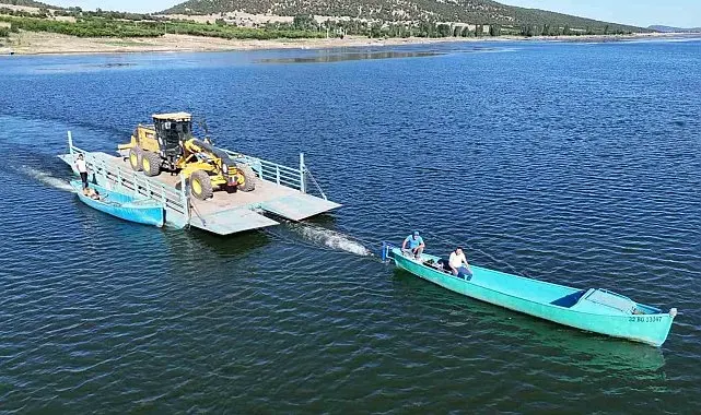 Adaya bakım yapacak olan iş makinesi tekneyle taşındı