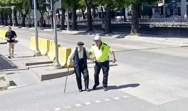Trafik polisinin yürümekte zorlanan yaşlı adama yardımı yürekleri ısıttı