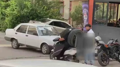 Ankara’da Otomobil Lastiğini Boynuna Asarak Seyreden Kurye Kamerada