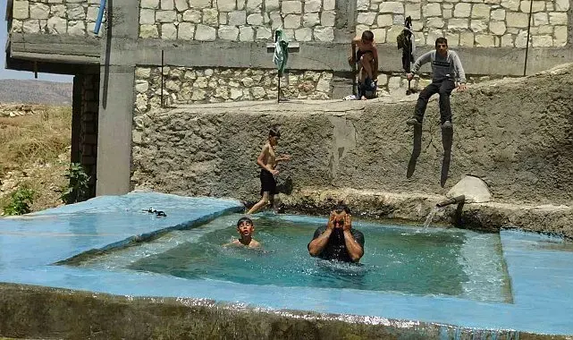 Gercüş ilçesinde sıcaktan bunalan çiftçiler buz gibi kaynak suyunda serinliyor