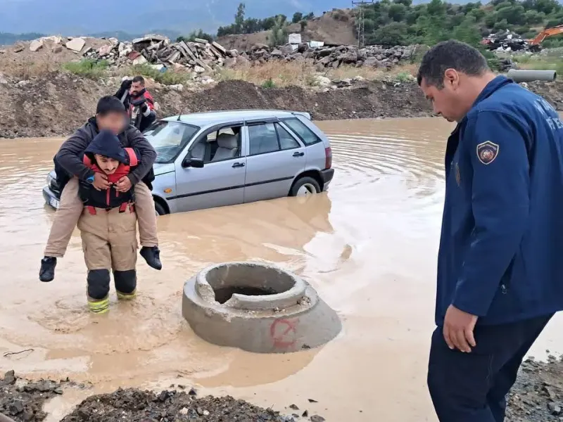 Hatay'da su basan yolda mahsur kalan çocuğu itfaiye eri sırtında kurtardı