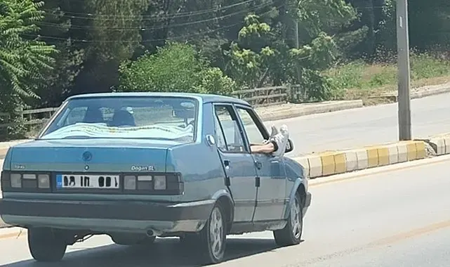 Ayaklarını camdan dışarı çıkartan yolcu trafiği riske attı