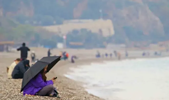 Antalya'da yağmura rağmen şemsiye altında deniz keyfi