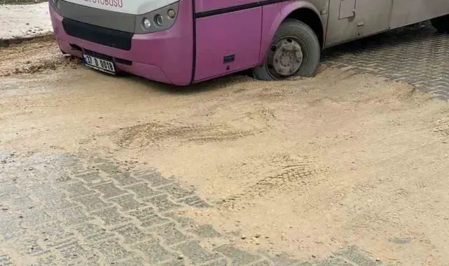 Özel halk otobüsü asfalt atılmayan caddede toprağa battı